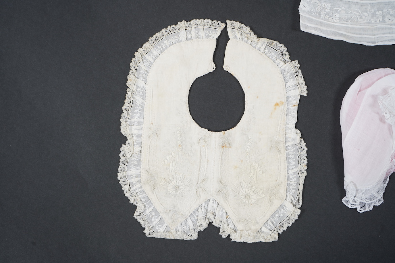 An 18th century Holly Point needle lace panelled linen baby bonnet, an early 19th century white worked baby bib and bonnet and a later 19th century finely ruffed lace bonnet (4). Condition - Holly Point bonnet and bib ha